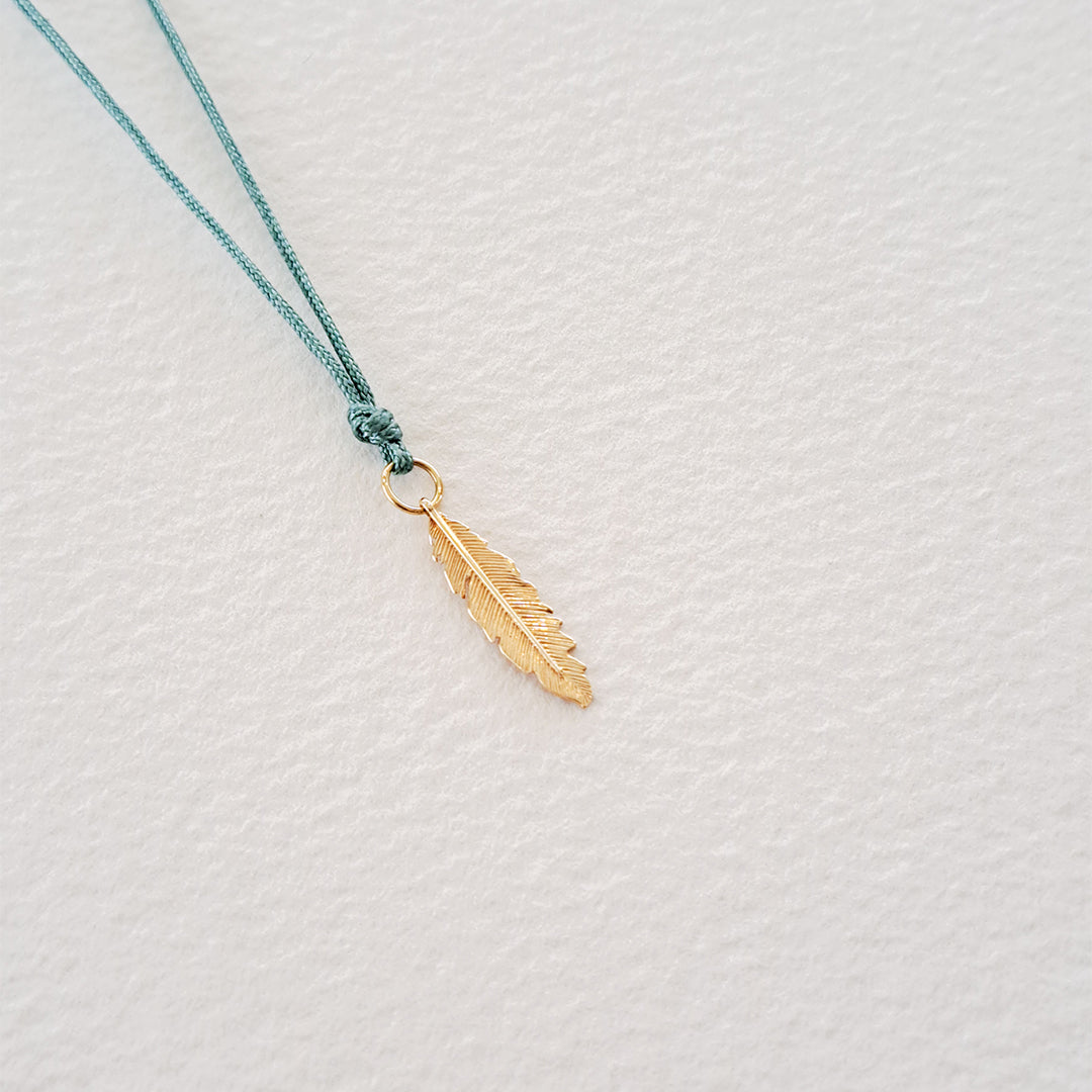 Feather pendant on thread